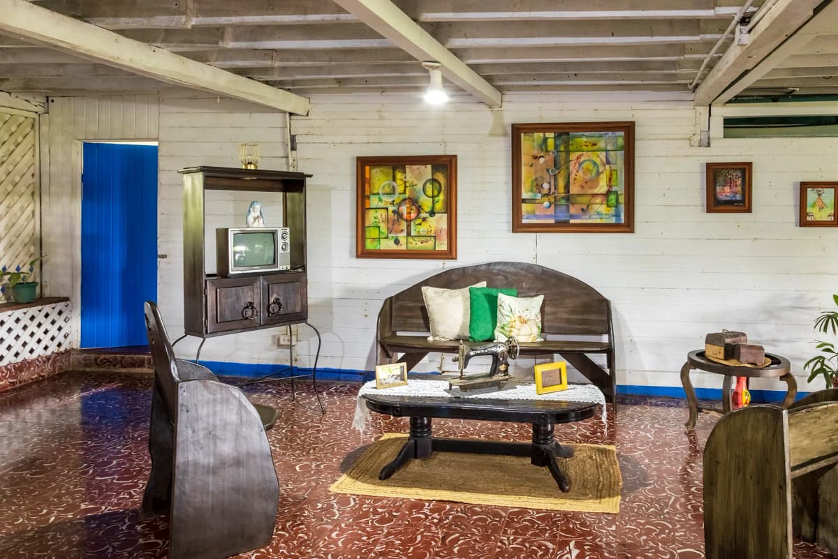 Perspectiva amplia de la sala rústica antigua con televisor vintage y puerta azul
