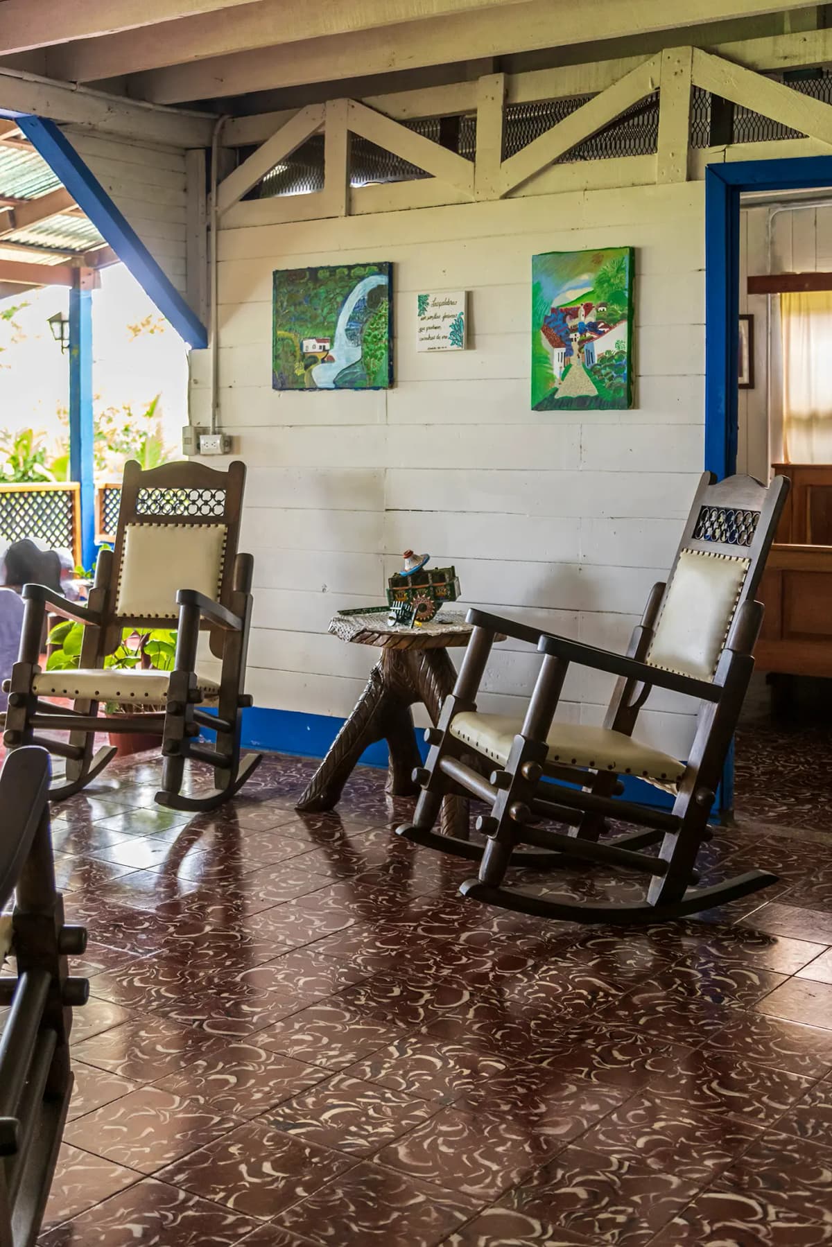 Mecedoras tradicionales de madera y cuero con carreta típica costarricense en miniatura