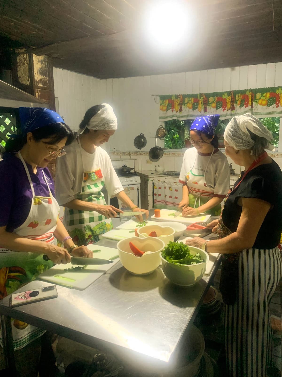 Grupo de visitantes picando ingredientes frescos en la mesa de preparación