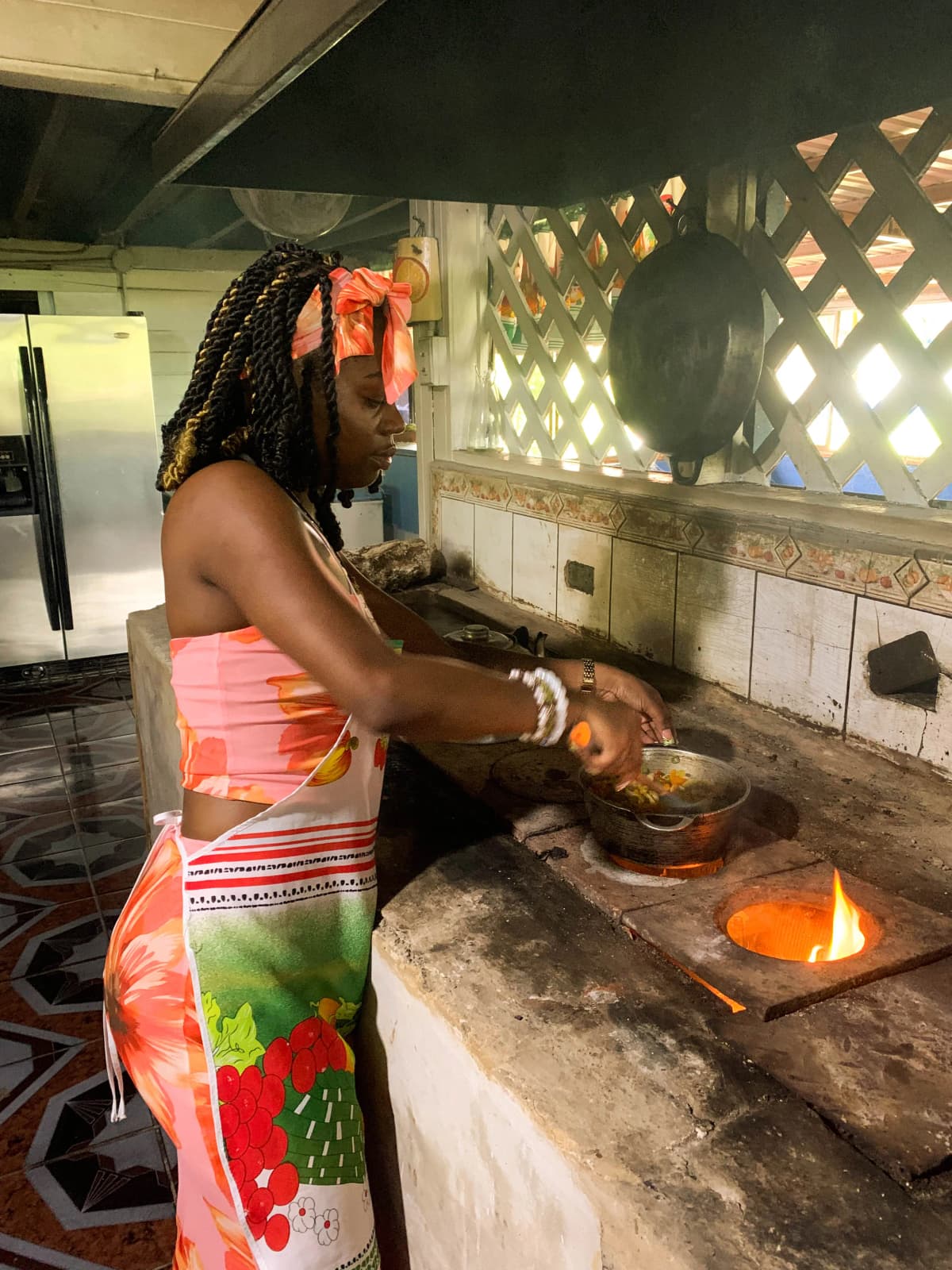 Visitante cocinando directamente sobre el fogón de leña en la cocina rústica