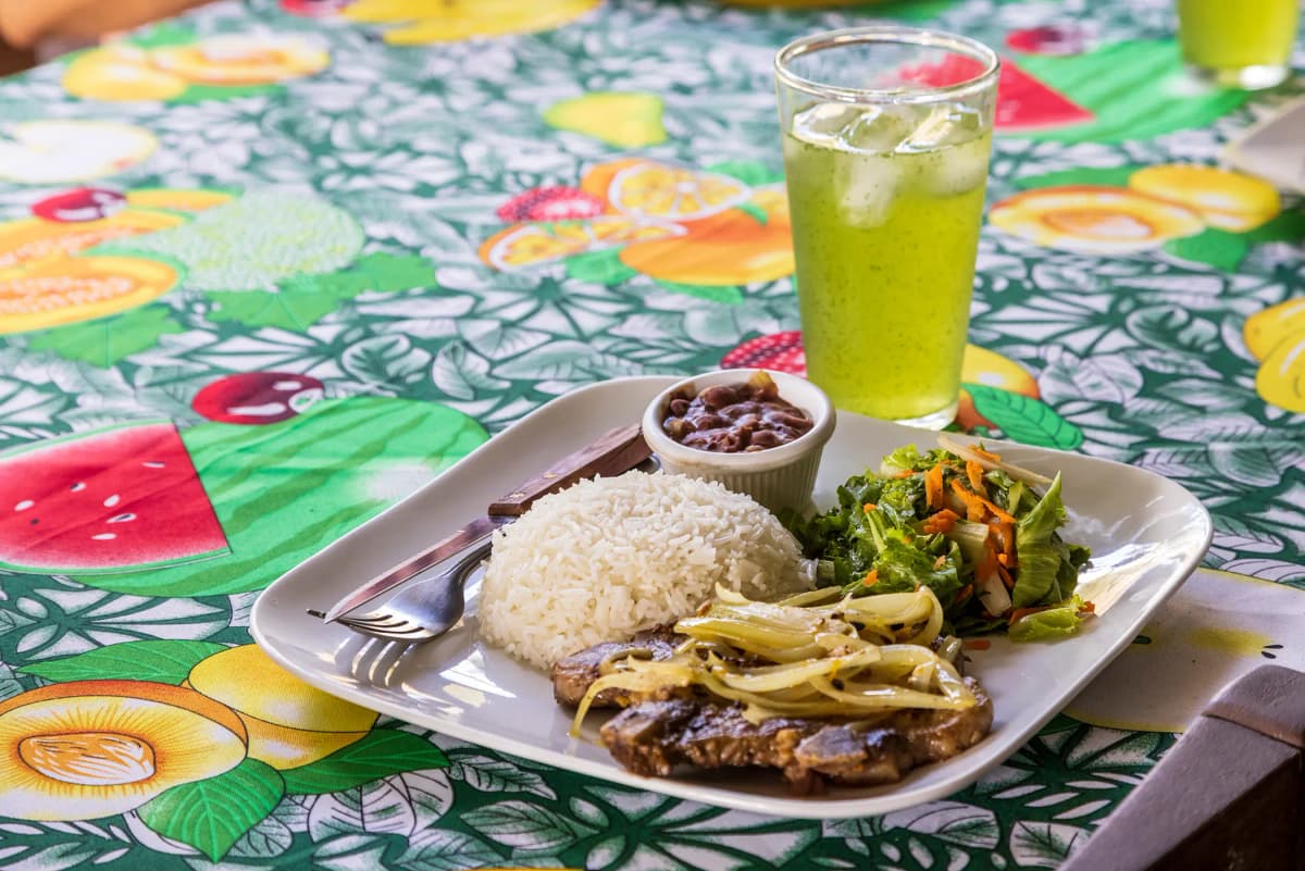 Casado tradicional costarricense servido con refresco natural fresco
